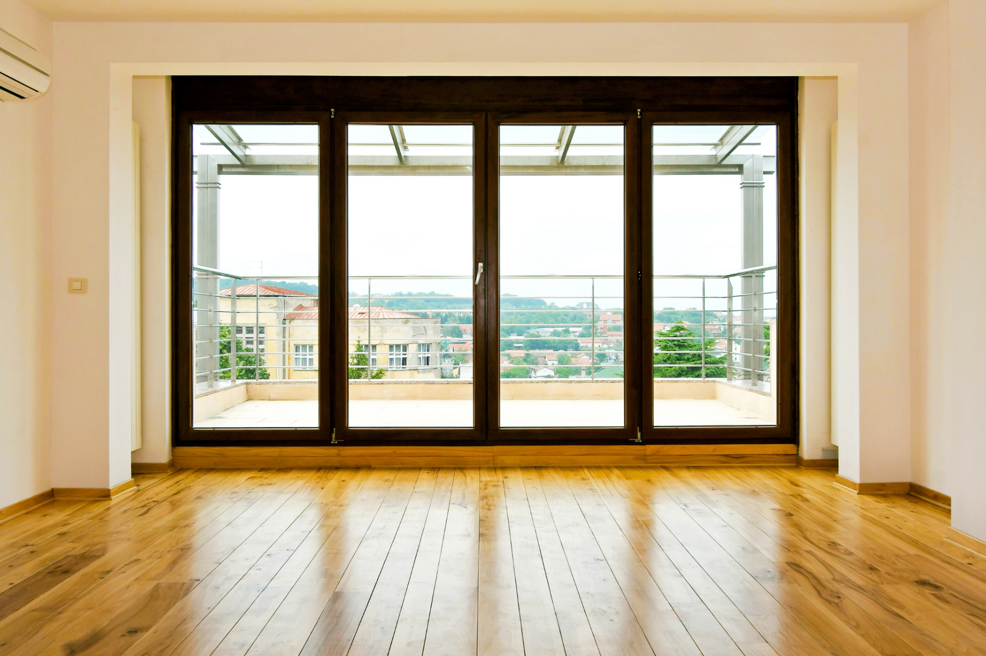 Portafinestra a libro in legno con quattro ante e vista panoramica sul terrazzo